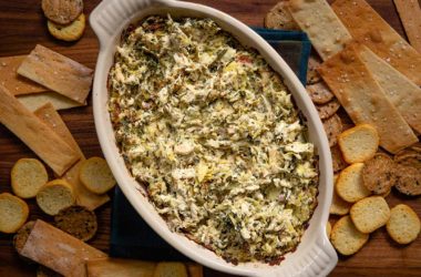 Bowl of tuscan chicken dip surrounded by crackers