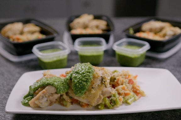 Lemon basil chicken thigh with quinoa and pesto plated as well in meal prep containers