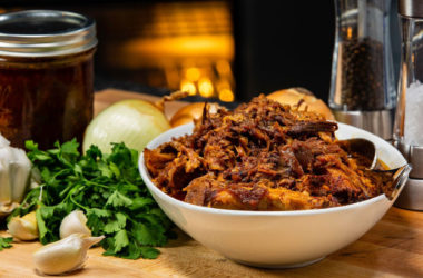 BBQ pulled pork in a bowl surrounded by ingredients