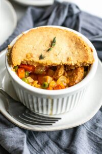 an individual ramekin of turkey pot pie with vegetables
