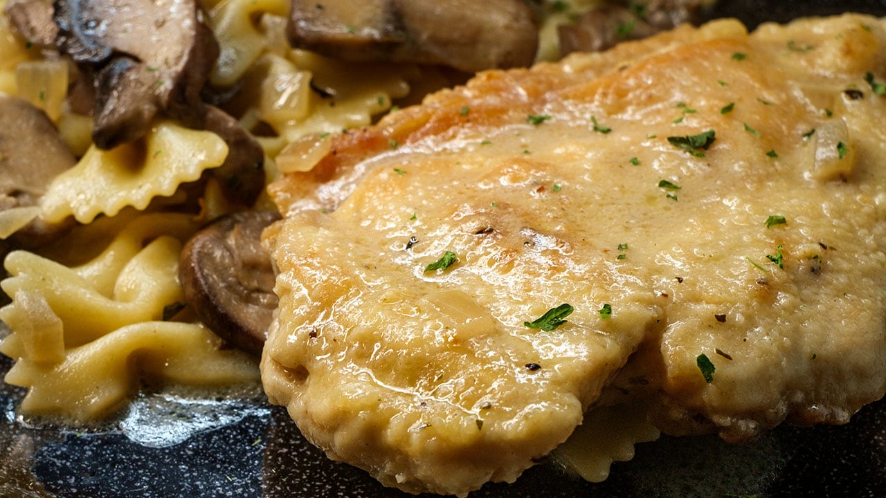 Chicken marsala with mushrooms in a creamy wine and whisky sauce over farfalle pasta