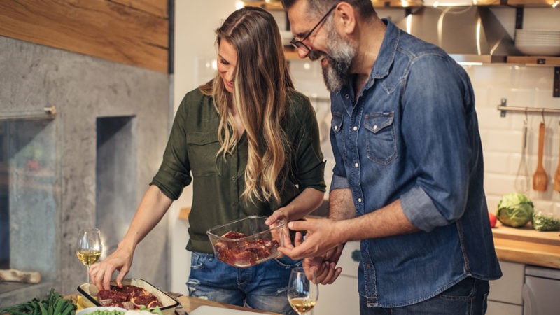 couple preparing steak dinner in kitchen on weeknight