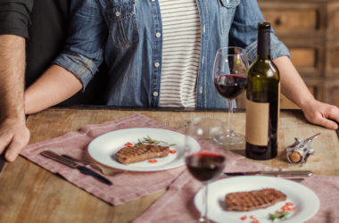 man and woman steak and wine romantic dinner