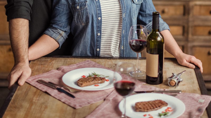 man and woman steak and wine romantic dinner