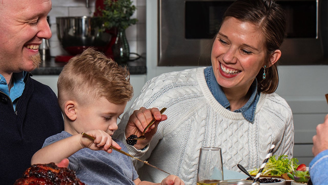 mom feeding kid fruit for breakfast