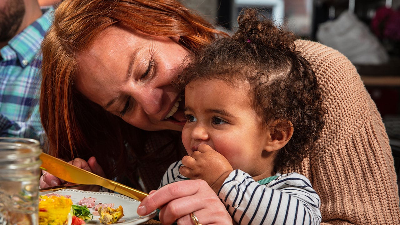 mom and daughter eating breakfast bacon