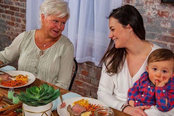 grandmother, mom, and child enjoying dinner