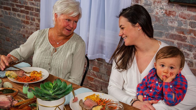 grandmother, mom, and child enjoying dinner