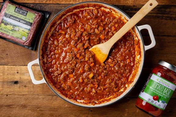 Fennel bolognese in a pot next to ground beef and marinara sauce