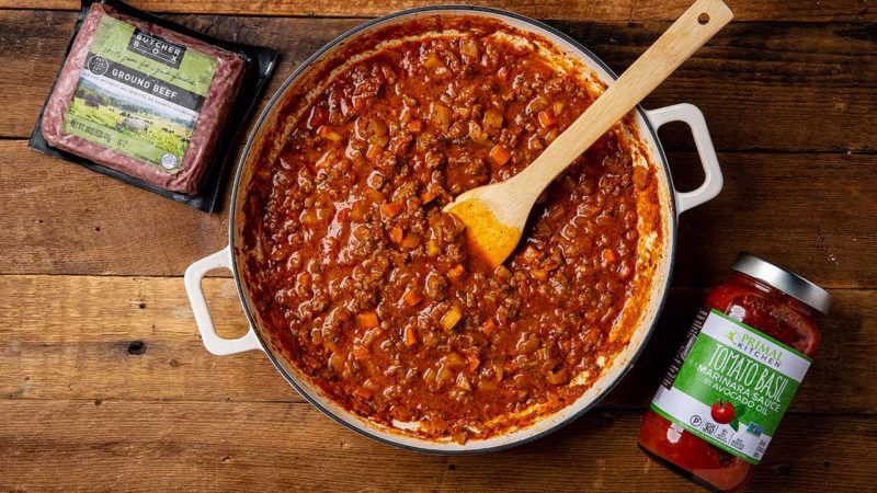 Fennel bolognese in a pot next to ground beef and marinara sauce