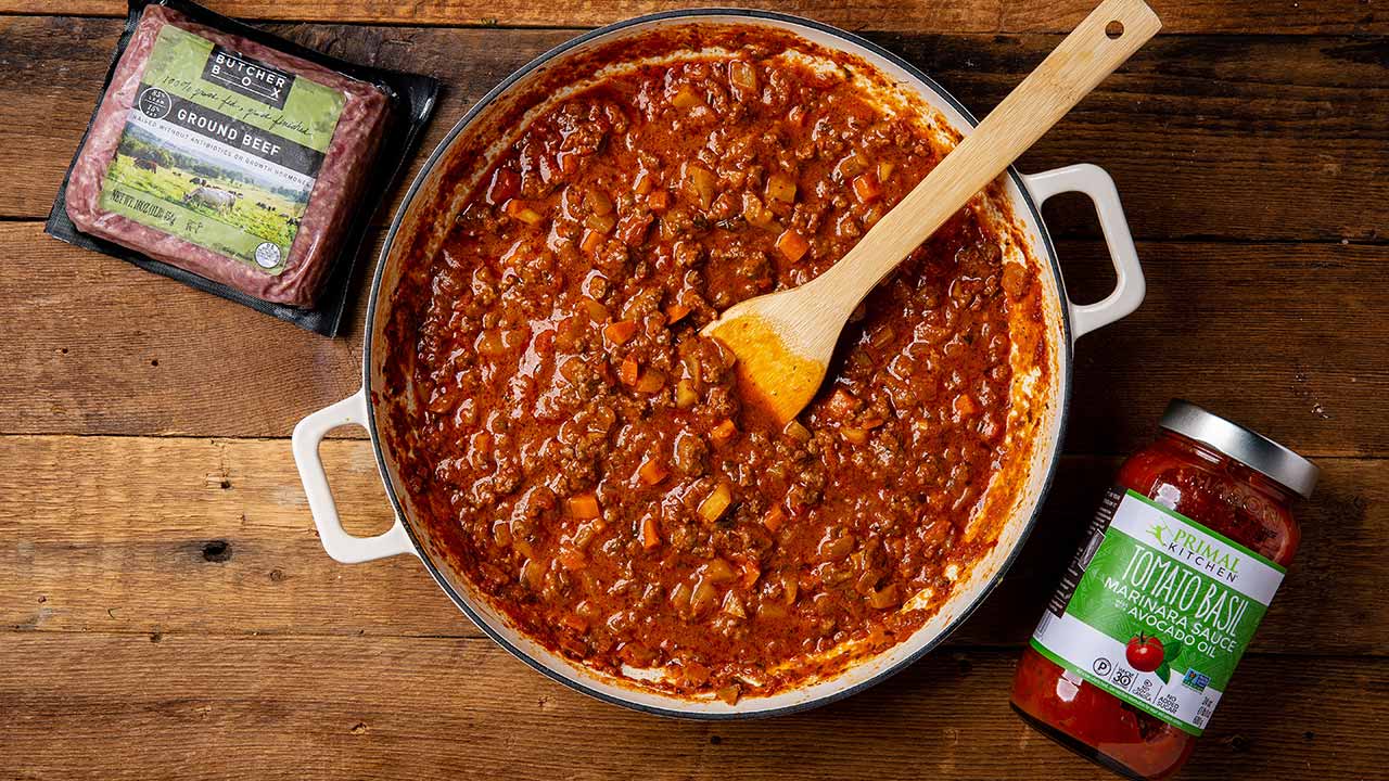 Fennel bolognese in a pot next to ground beef and marinara sauce
