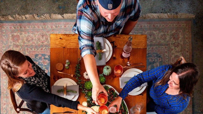 friendsgiving table with friends raising glasses