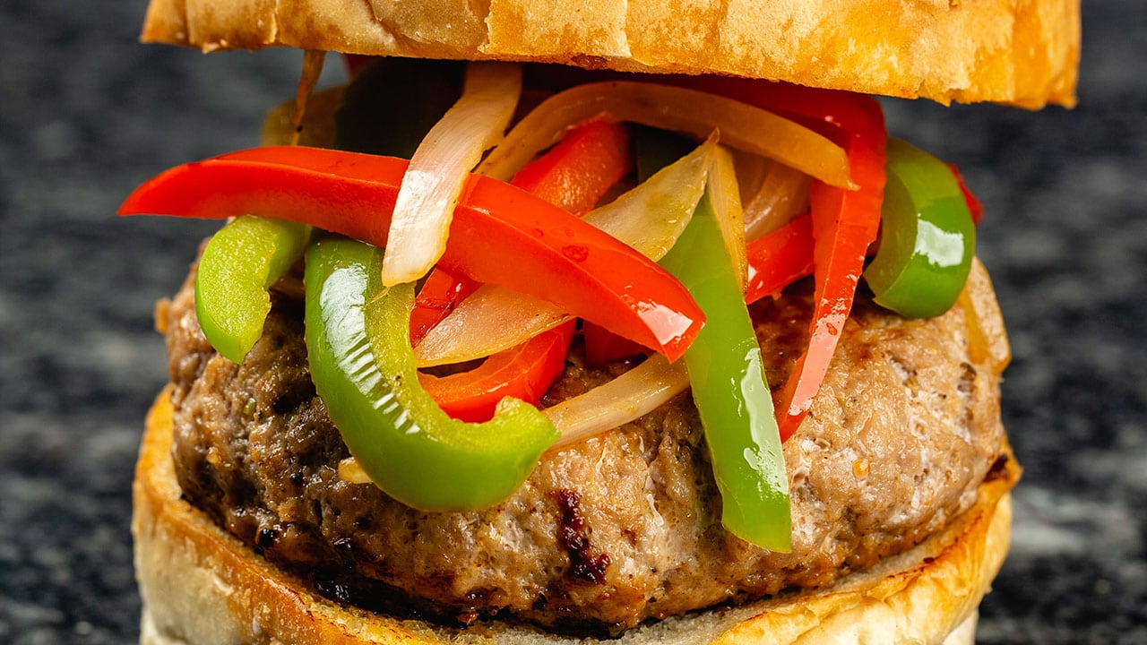 burger bun filled with patty tomato and chillis