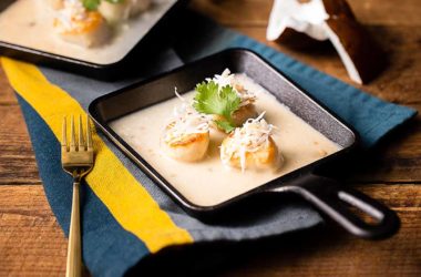 seared scallops in coconut cream sauce in a skillet