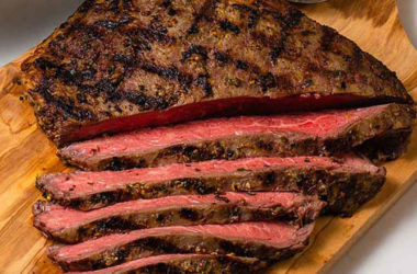 Sliced flank on a cutting board with chives