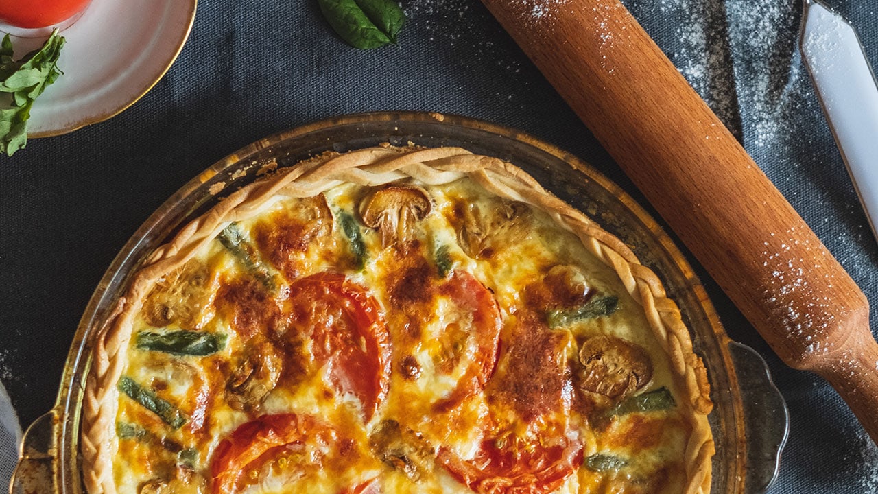 Quiche with asparagus, tomatoes, mushrooms, and Swiss