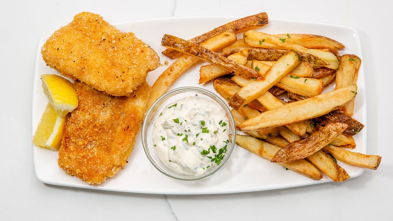 cod fish and chips plate with tartar sauce and lemon wedges