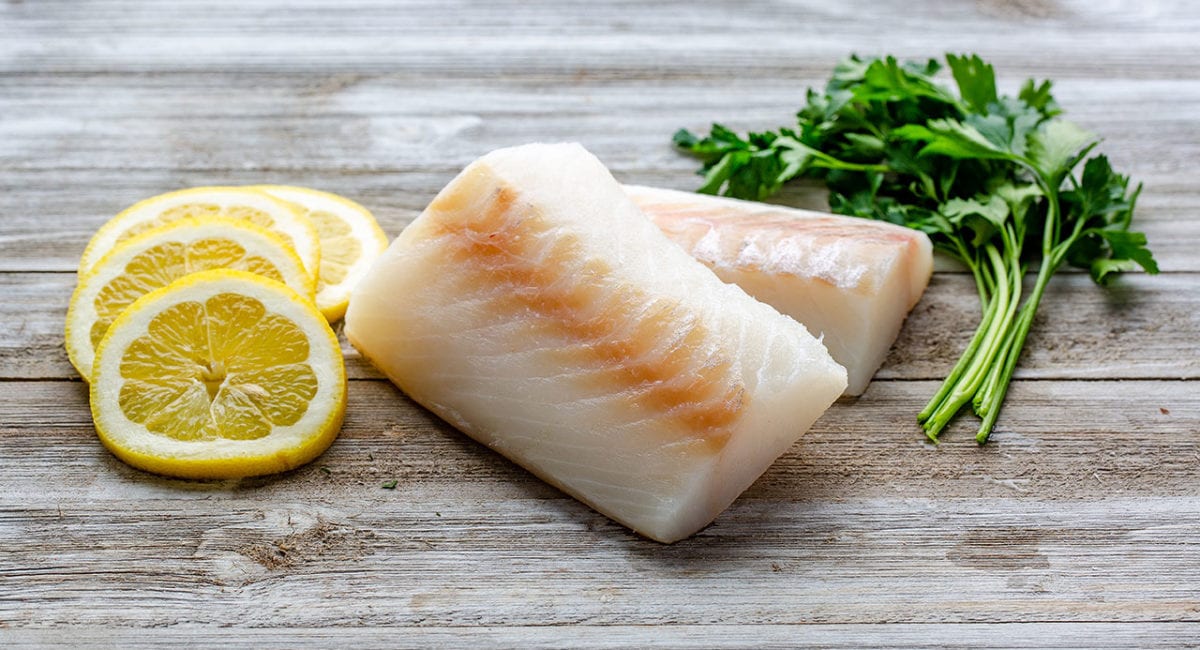 Frozen cod filet with lemon rounds and herbs