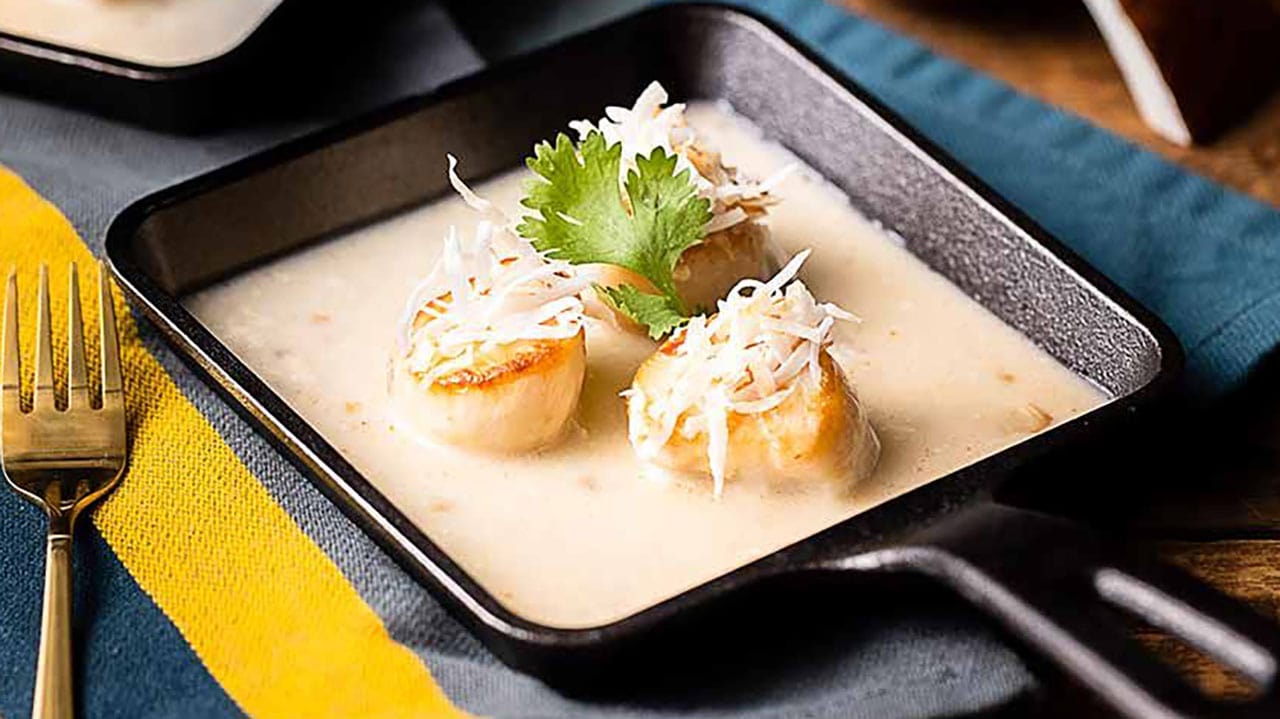 cast-iron pan with seared scallops and sauce