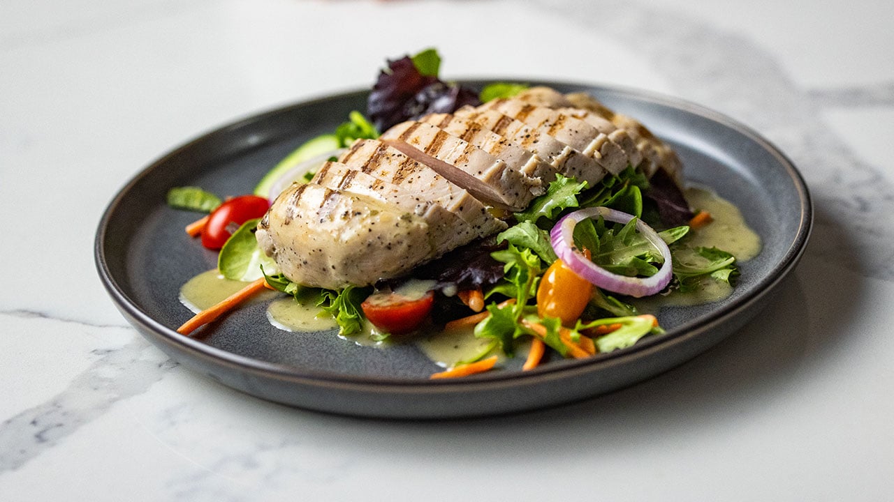 ButcherBox Complete chicken on a bed of greens and veggies