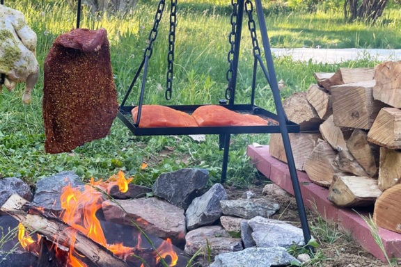 grilling steak chicken and salmon over open fire