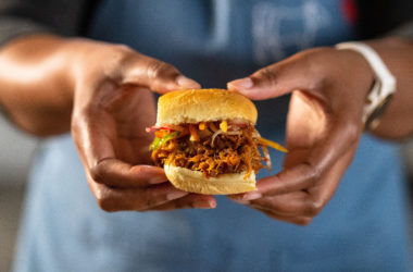 woman holding pulled pork sandwich