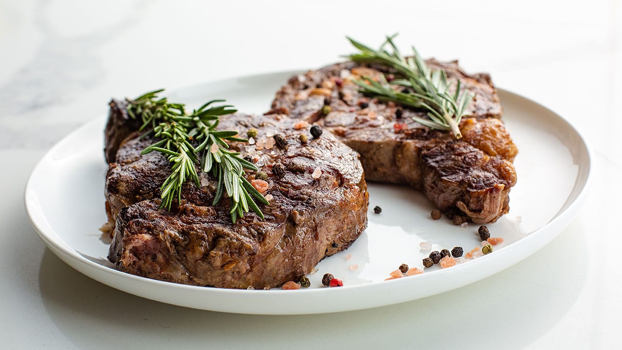 ribeye steak topped with pink Himalayan salt, peppercorn, and rosemary