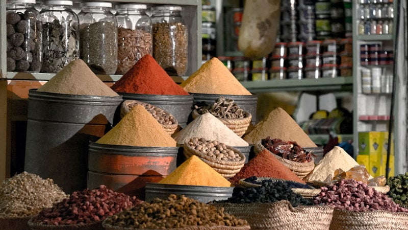 bins and jars filled with spices at a market