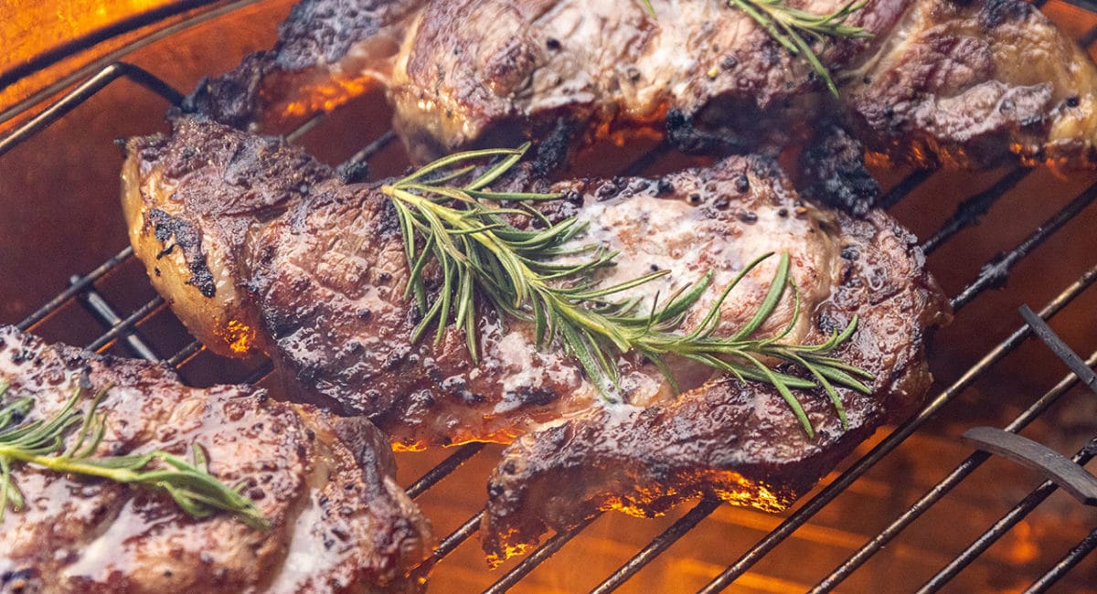 steaks cooking on grill