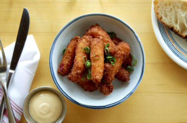 Lobster and scallion fritters in a bowl with chopped scallions sprinkled on top