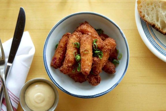Lobster and scallion fritters in a bowl with chopped scallions sprinkled on top