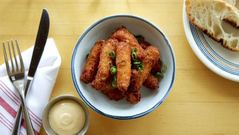 Lobster and scallion fritters in a bowl with chopped scallions sprinkled on top
