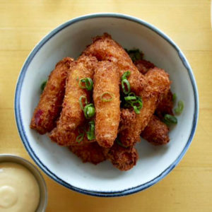 Lobster and scallion fritters in a bowl with chopped scallions sprinkled on top