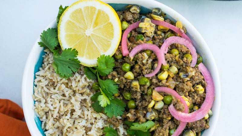 picadillo criollo in a bowl with a lemon wedge