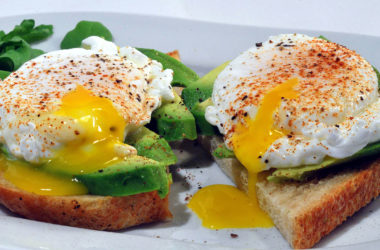 two slices of toast topped with avocado and poached eggs