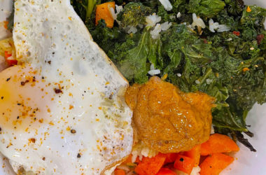 roasted kale, carrots, chili mayo, and a fried egg over crispy rice in a bowl