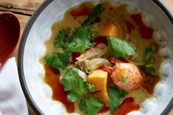 green curry lobster stew in bowl with spoon