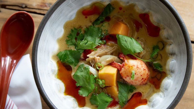 green curry lobster stew in bowl with spoon