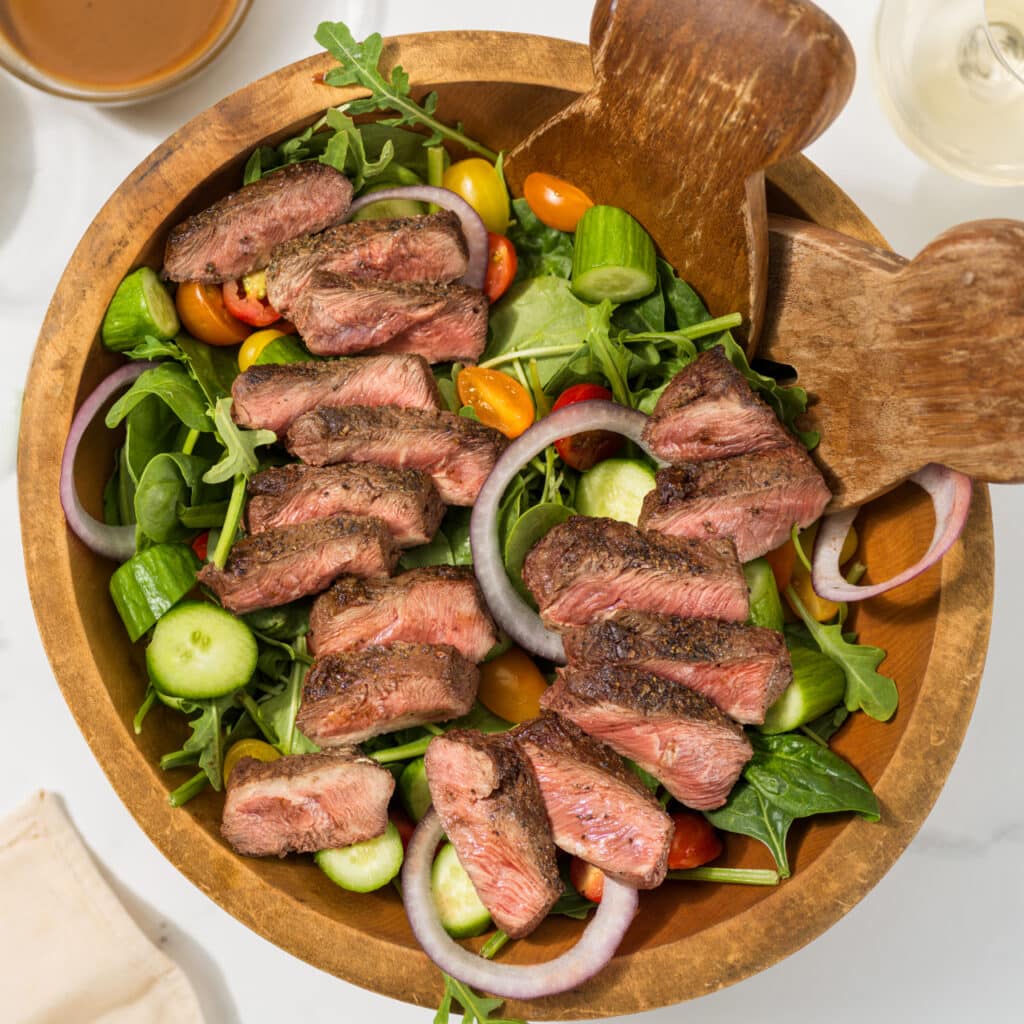 flat iron steak with vegetables on a bowl