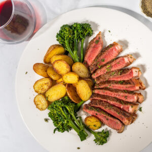 NY strip with potato and vegetable on a plate