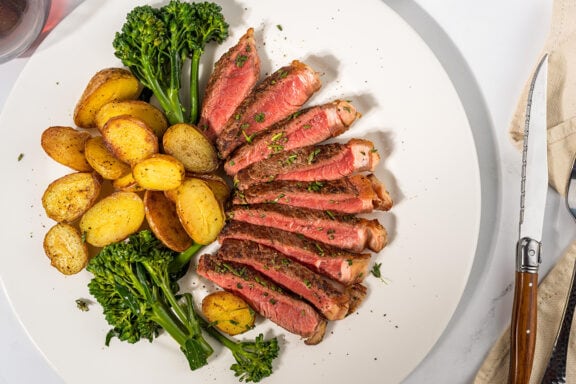 NY strip with potato and vegetable on a plate