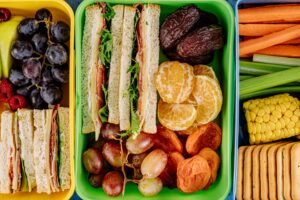 lunchboxes filled with sandwiches and fruit