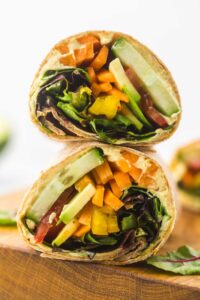 veggie hummus wrap stacked on a chopping block
