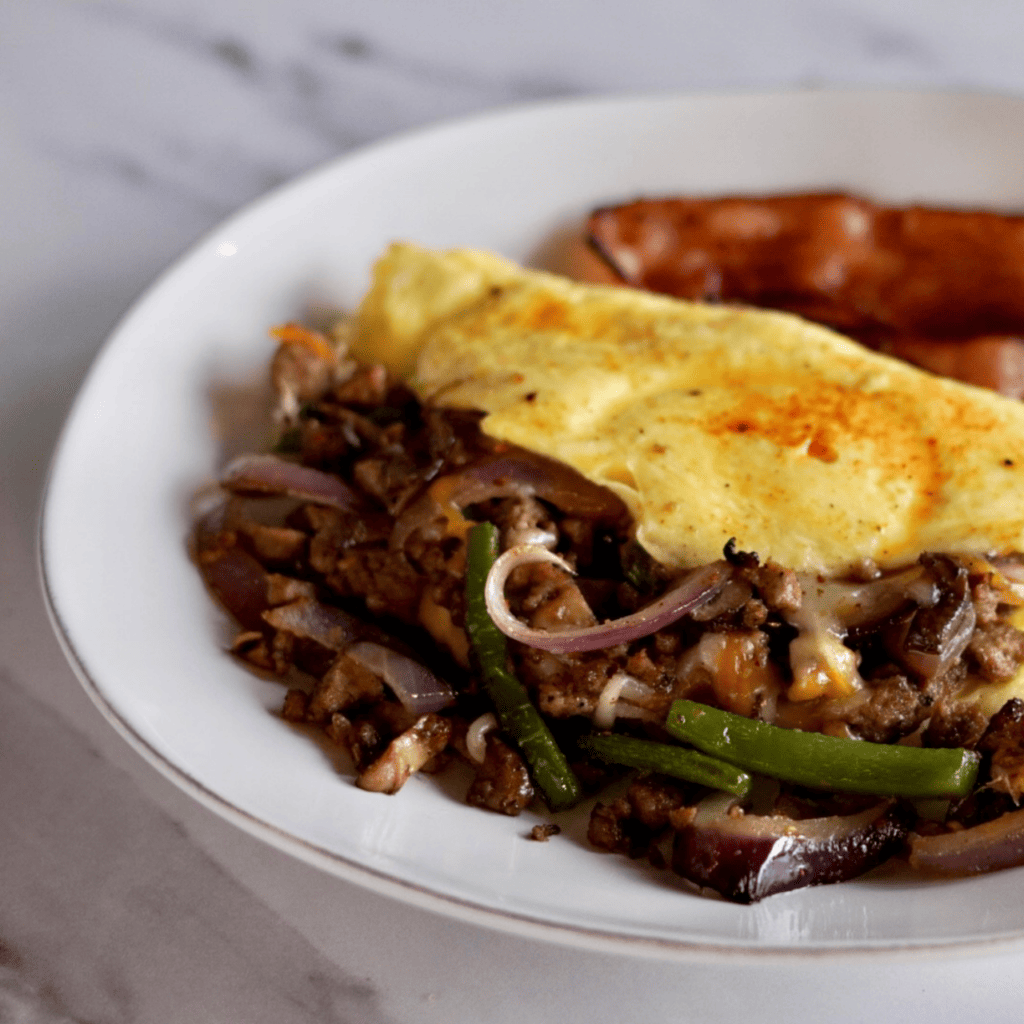 omelette next to a hotdog on a plate