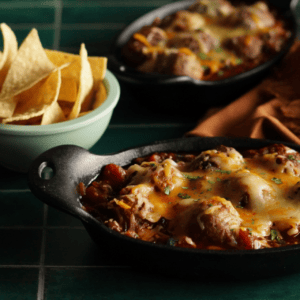 meatball skillet with sauce next to bowl full of nachos