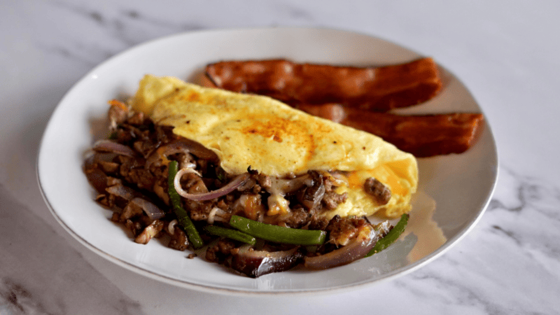 omelette next to a hotdog on a plate