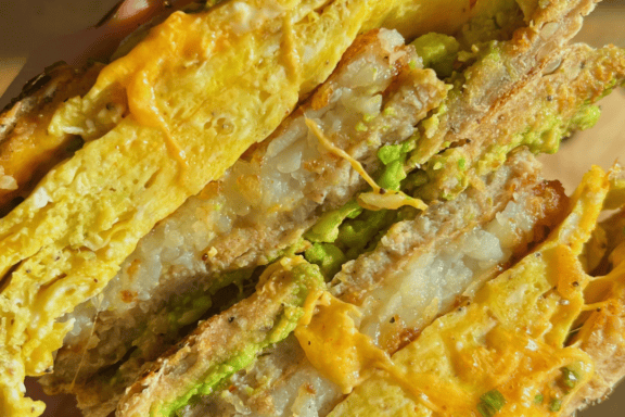 bagel sandwich filled with sausage patty hash brown patty and egg